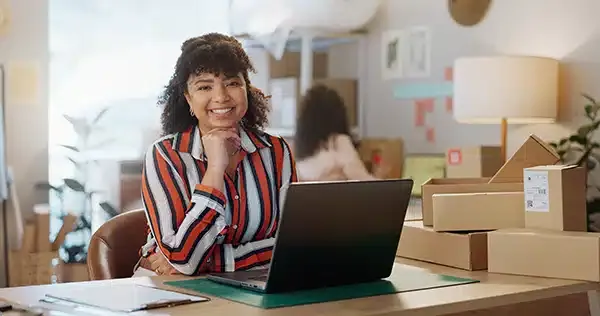 Woman smiling in front of laptop.