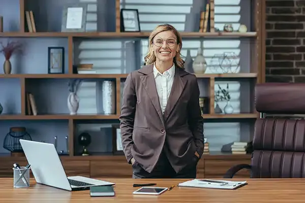Woman standing in office space in front of laptop in Denver, CO.
