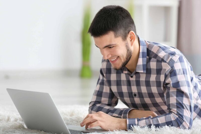 Man looking at his computer smiling